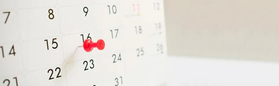 Chincheta roja marcando una fecha concreta en un calendario