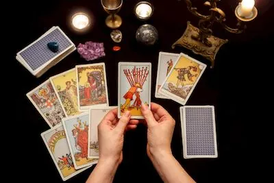 Predicción de tarot: manos sosteniendo una carta sobre una tirada