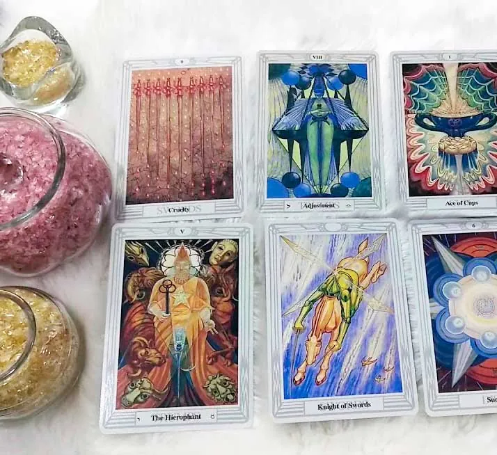 Cartas de tarot junto a frascos con cuarzos y cristales